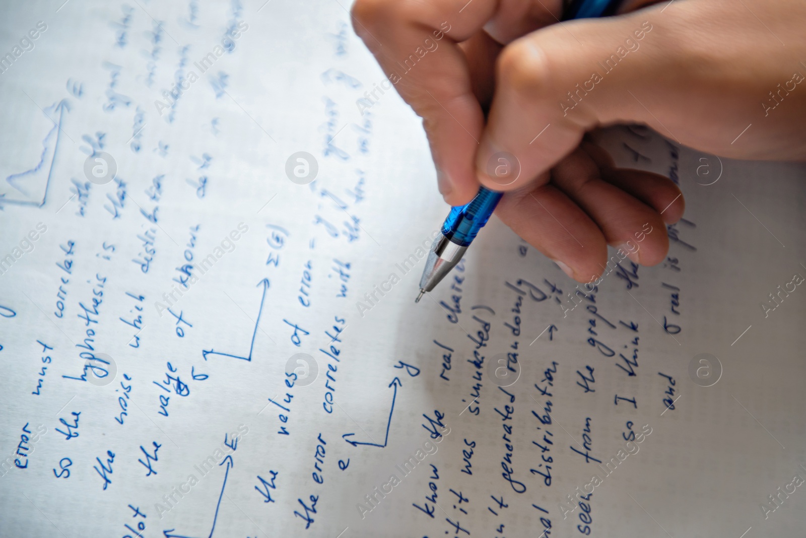 Photo of Student writing mathematical calculations on paper, closeup