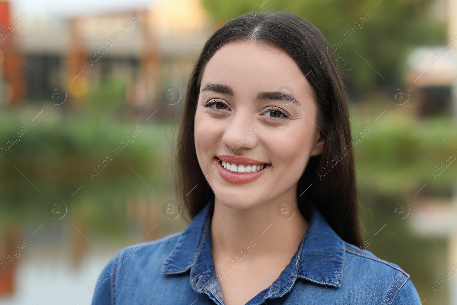 Photo of Portrait of beautiful woman outdoors. Attractive lady smiling and looking into camera