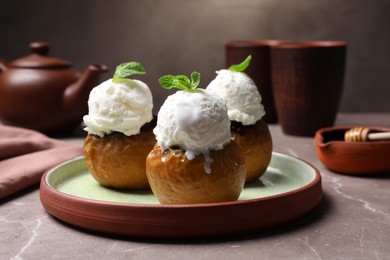 Photo of Delicious baked apples with ice cream and mint served on grey table