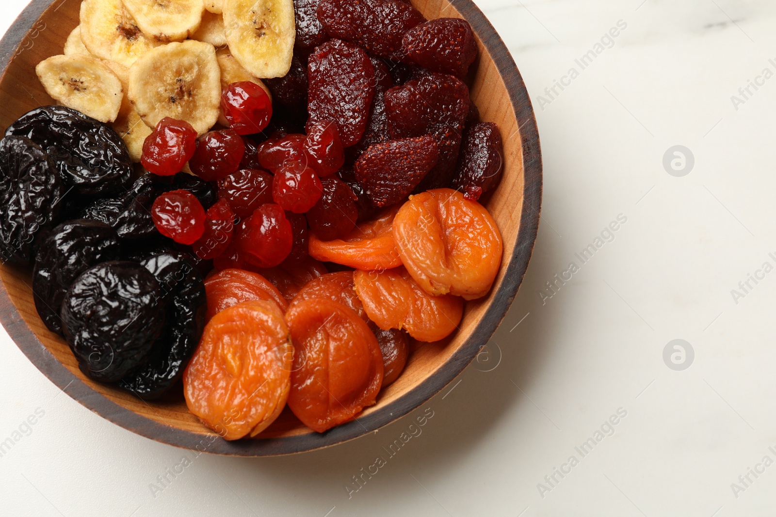 Photo of Mix of delicious dried fruits on white marble table, top view