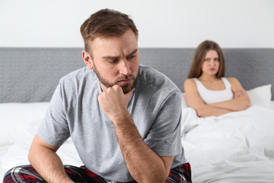 Photo of Unhappy couple with relationship problems after quarrel in bedroom