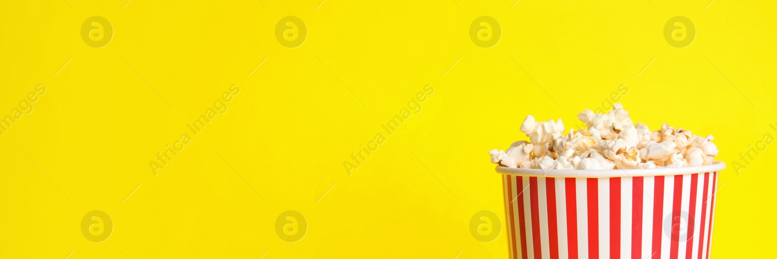 Image of Tasty popcorn on yellow background, space for text. Banner design