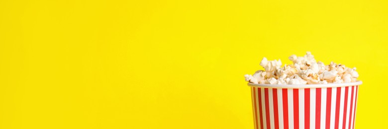 Image of Tasty popcorn on yellow background, space for text. Banner design