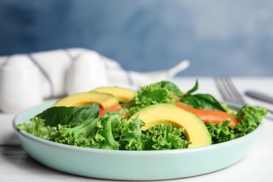 Photo of Delicious avocado salad with salmon on white wooden table