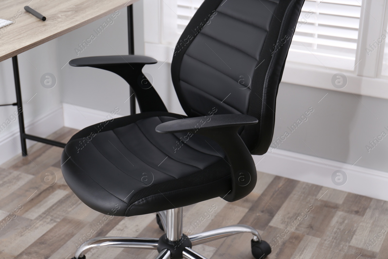 Photo of Comfortable office chair near table in room