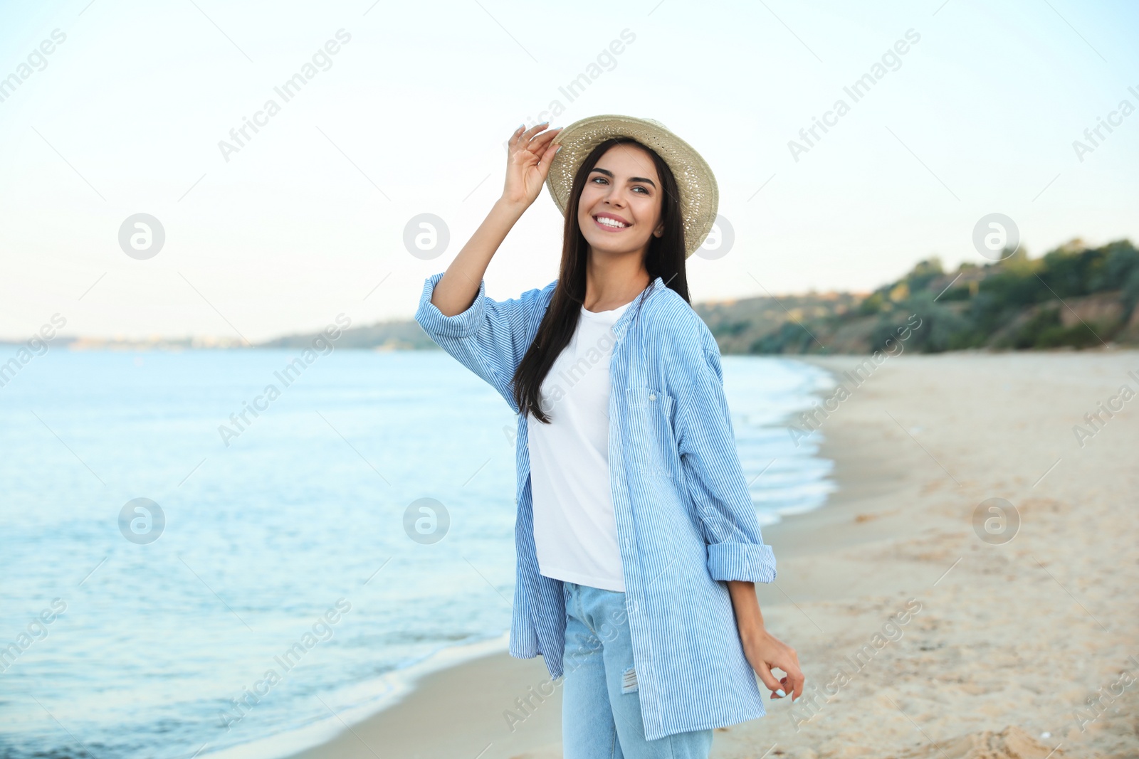 Photo of Beautiful young woman in casual outfit on beach