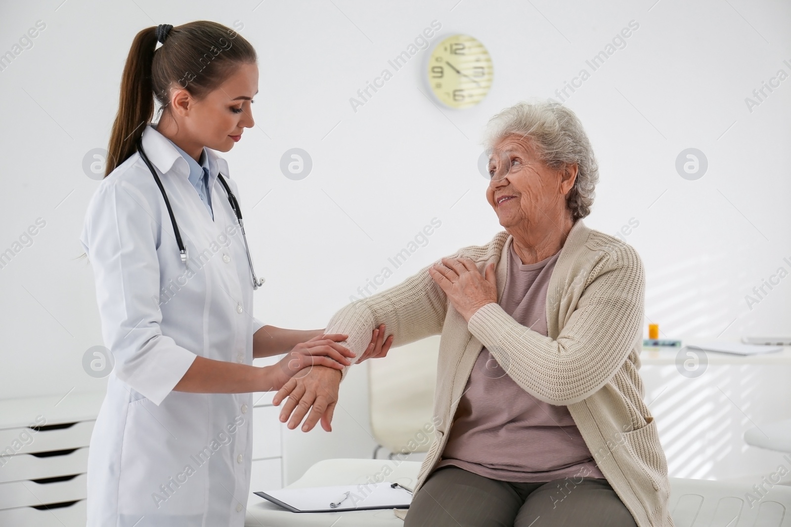 Photo of Doctor examining senior patient in modern office