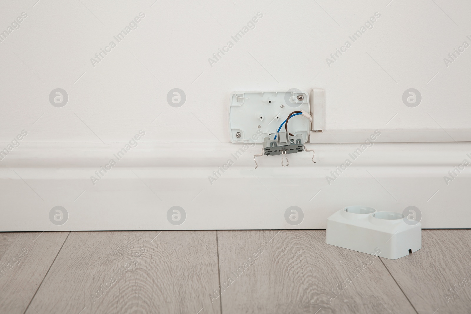 Photo of Broken sockets on white wall indoors. Electrician service