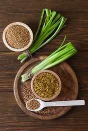 Tray with delicious whole grain mustard, seeds and fresh green onion on wooden table, flat lay