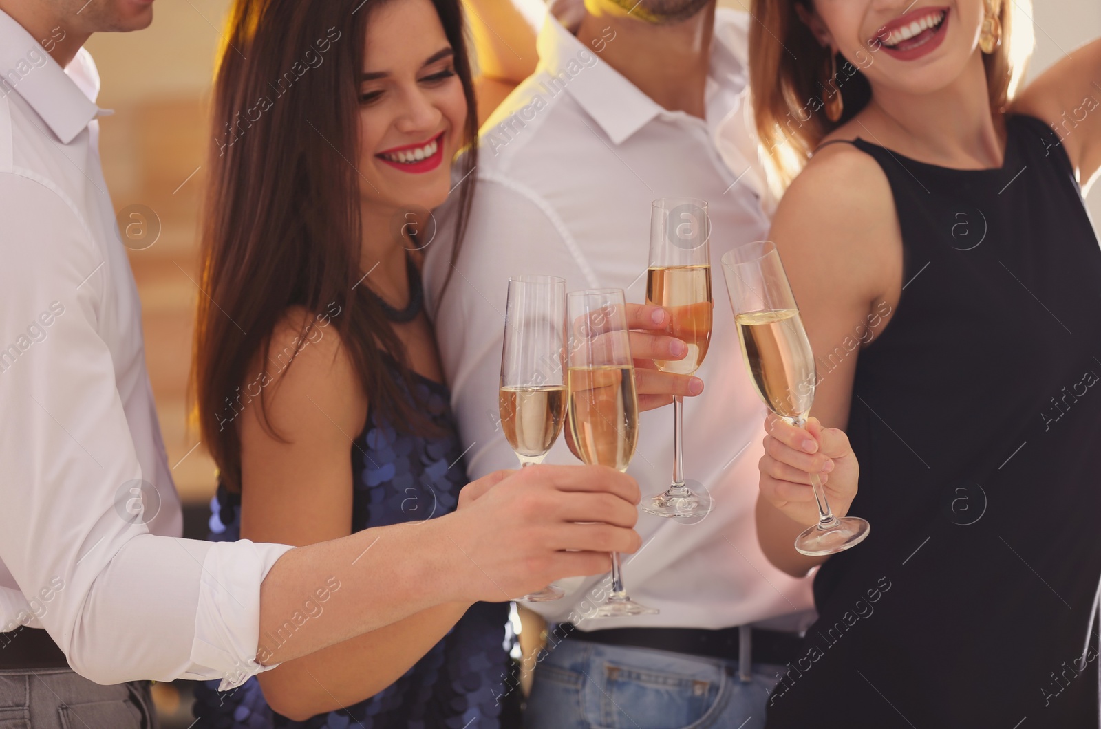 Photo of Friends clinking glasses with champagne at party, closeup