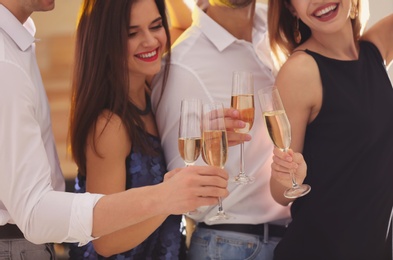 Photo of Friends clinking glasses with champagne at party, closeup