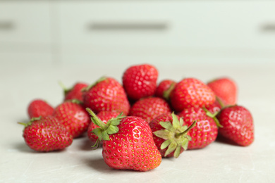 Photo of Delicious ripe strawberries on light grey table, closeup