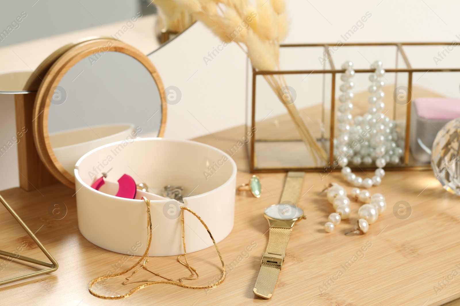 Photo of Jewelry box with many different accessories, wristwatch and decor on wooden table