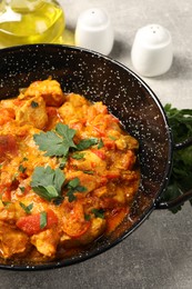 Photo of Delicious chicken curry in frying pan on light grey table