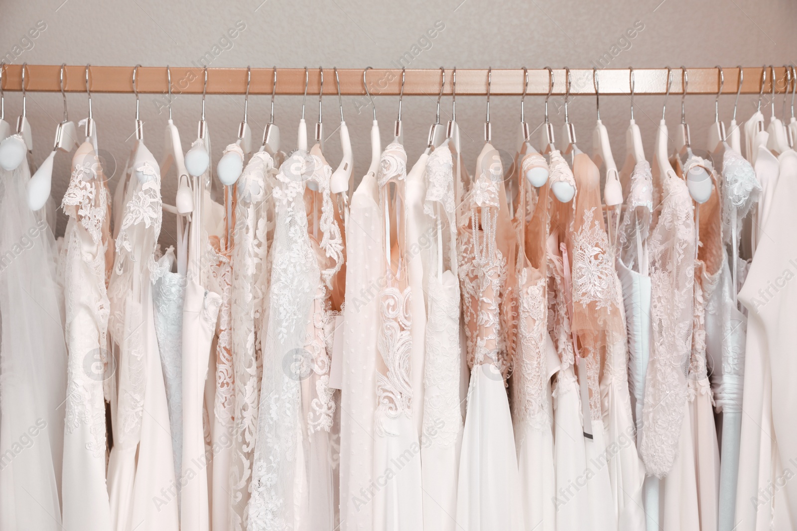 Photo of Different wedding dresses on hangers in boutique