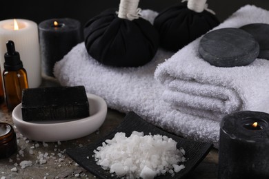 Composition with different spa products and burning candles on table, closeup