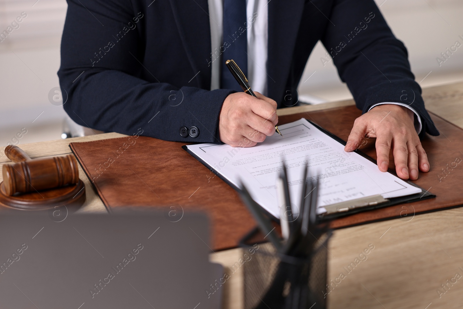 Photo of Notary working at wooden table in office, closeup