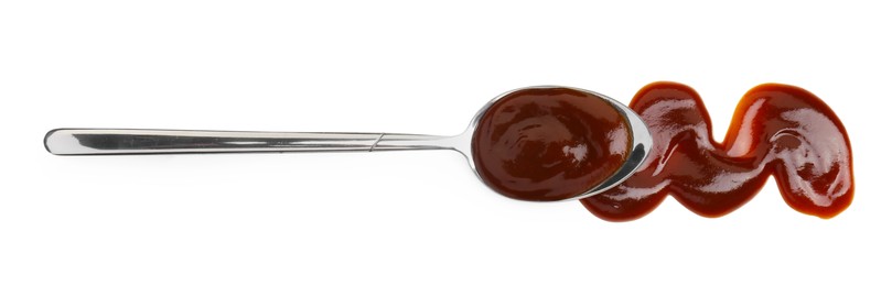 Photo of Tasty barbecue sauce and spoon isolated on white, top view