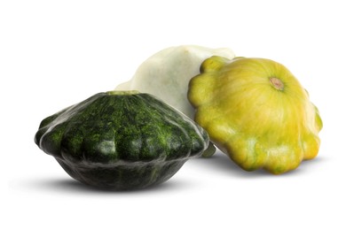 Three fresh different pattypan squashes on white background