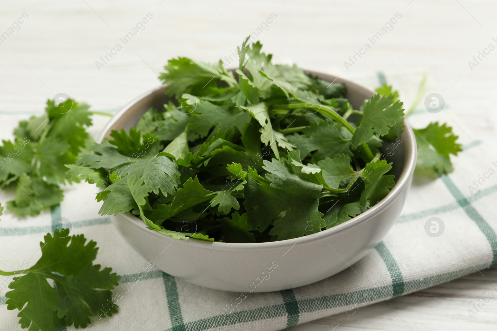 Photo of Fresh aromatic cilantro on white wooden table, closeup