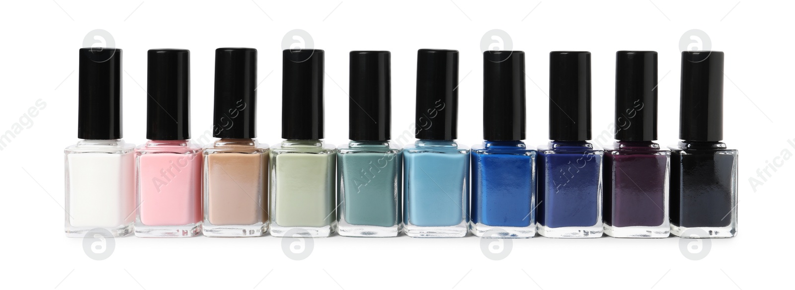 Photo of Beautiful nail polishes in bottles isolated on white