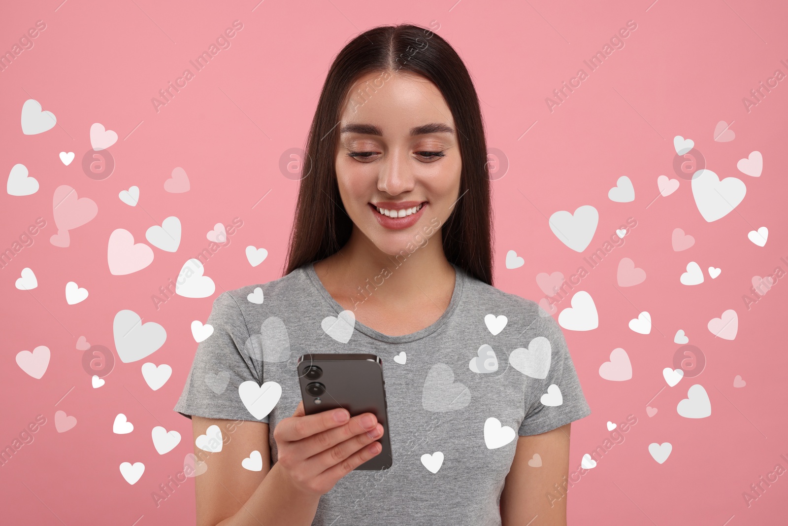 Image of Long distance love. Woman chatting with sweetheart via smartphone on pink background. Hearts flying out of device and swirling around her