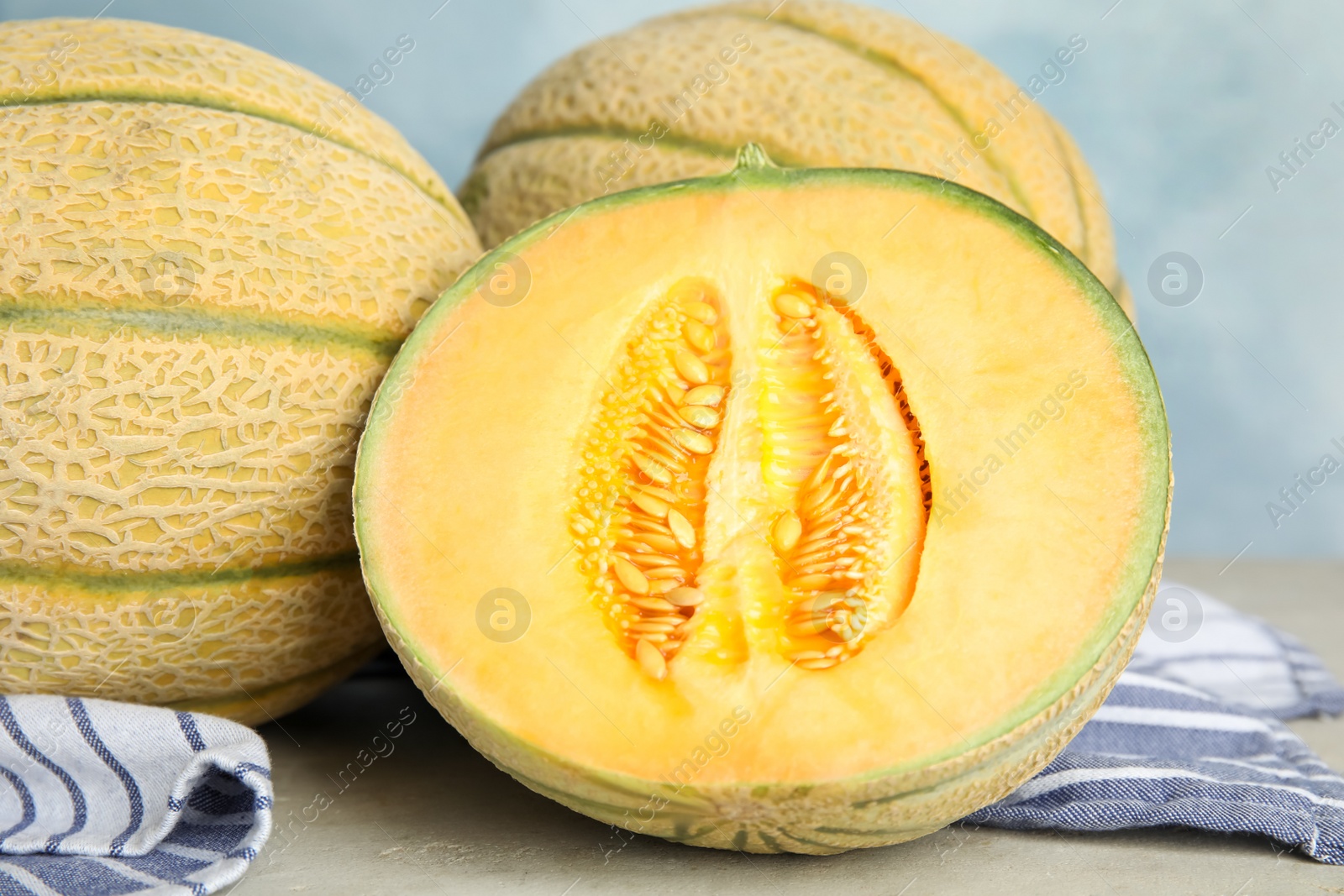 Photo of Tasty fresh melons on light grey table, closeup