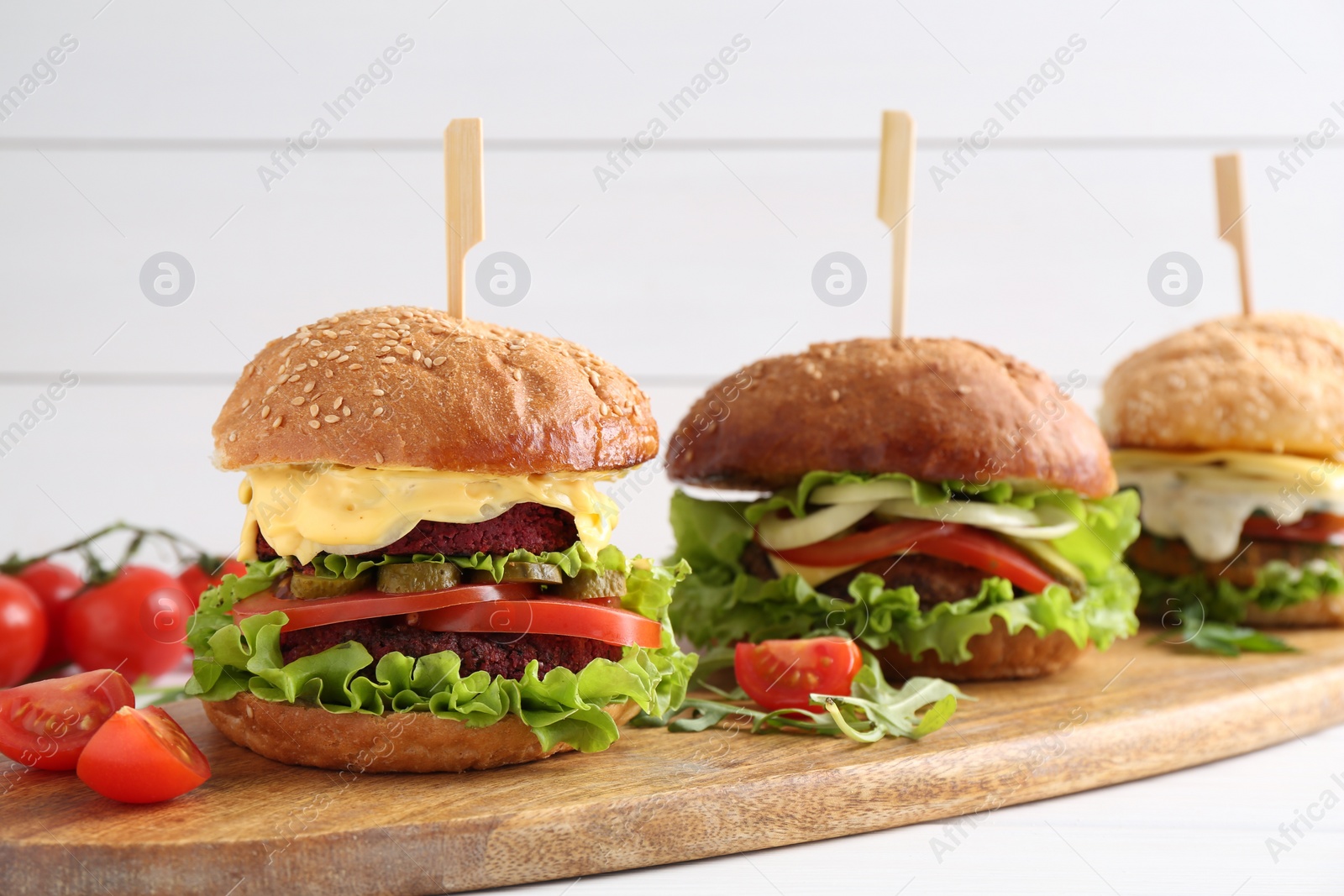 Photo of Delicious vegetarian burgers served on white table