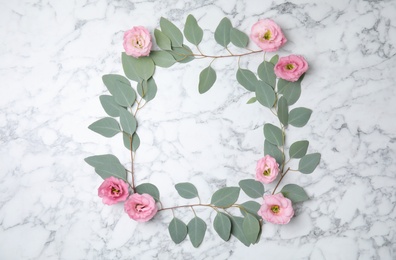 Photo of Fresh eucalyptus leaves with flowers and space for design on marble background, flat lay