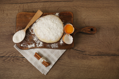 Flat lay composition with raw egg and other ingredients on wooden table. Baking pie