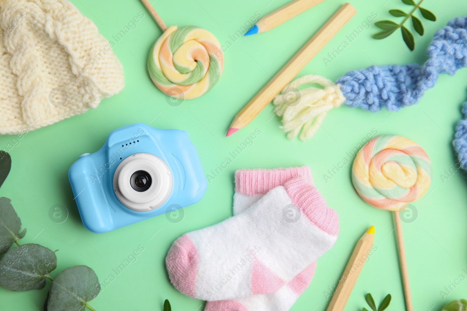 Photo of Flat lay composition with toy camera on light green background. Future photographer