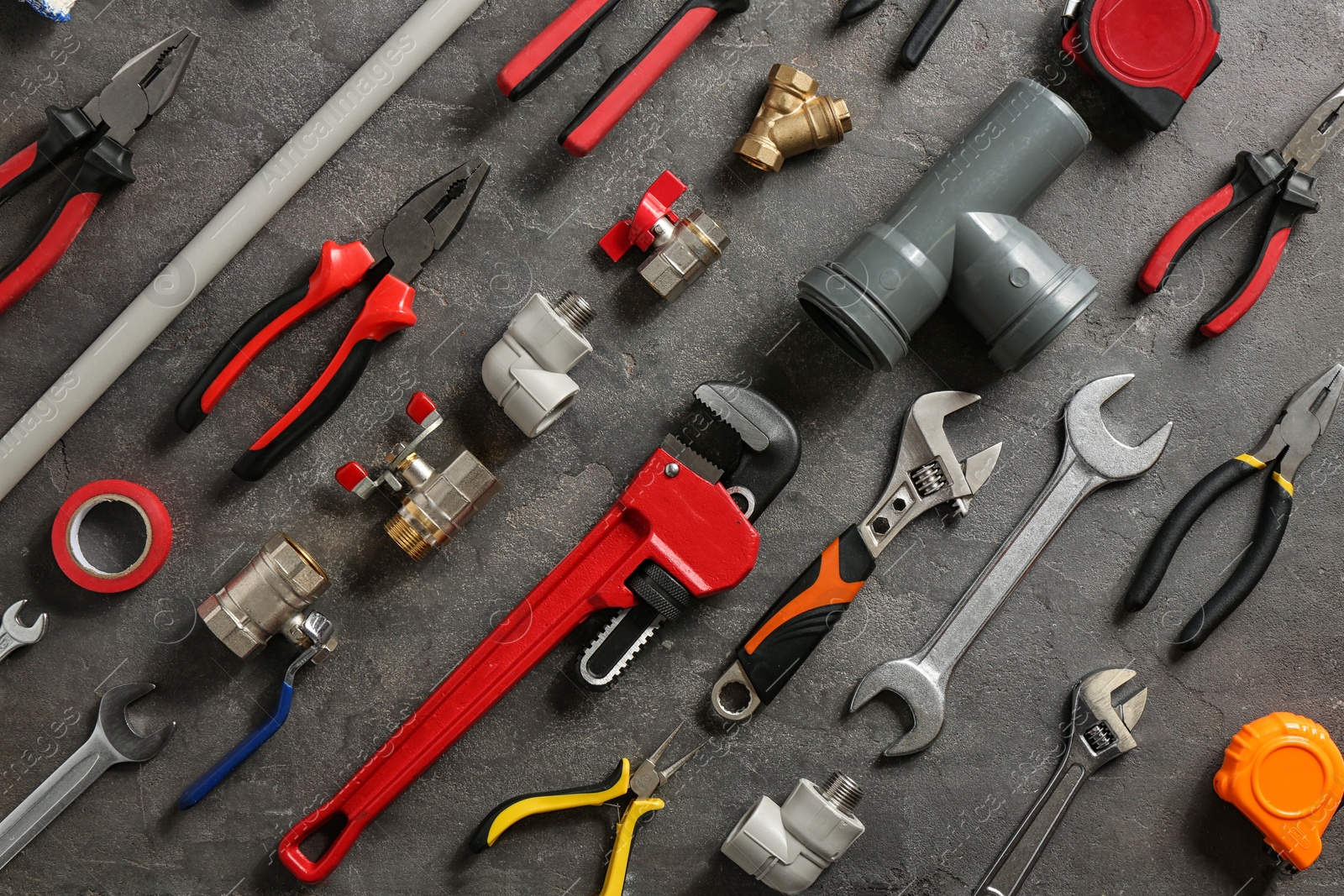 Photo of Flat lay composition with plumber's tools on grey background