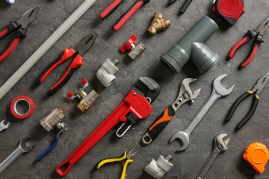 Photo of Flat lay composition with plumber's tools on grey background