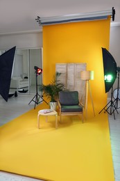 Photo of Stylish furniture in photo studio with professional equipment