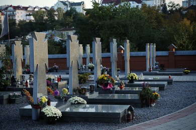 Photo of Many granite tombstones on cemetery. Funeral ceremony