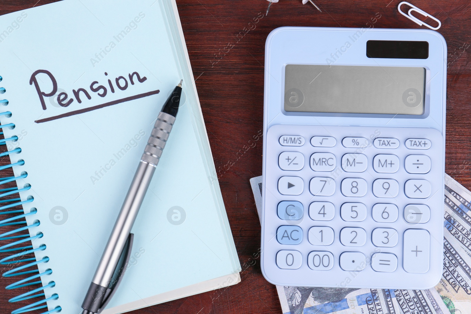 Photo of Calculator, notebook with word Pension, pen and dollar banknotes on wooden table, flat lay. Retirement concept