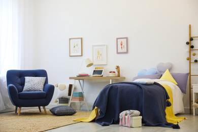 Modern teenager's room interior with bed and armchair