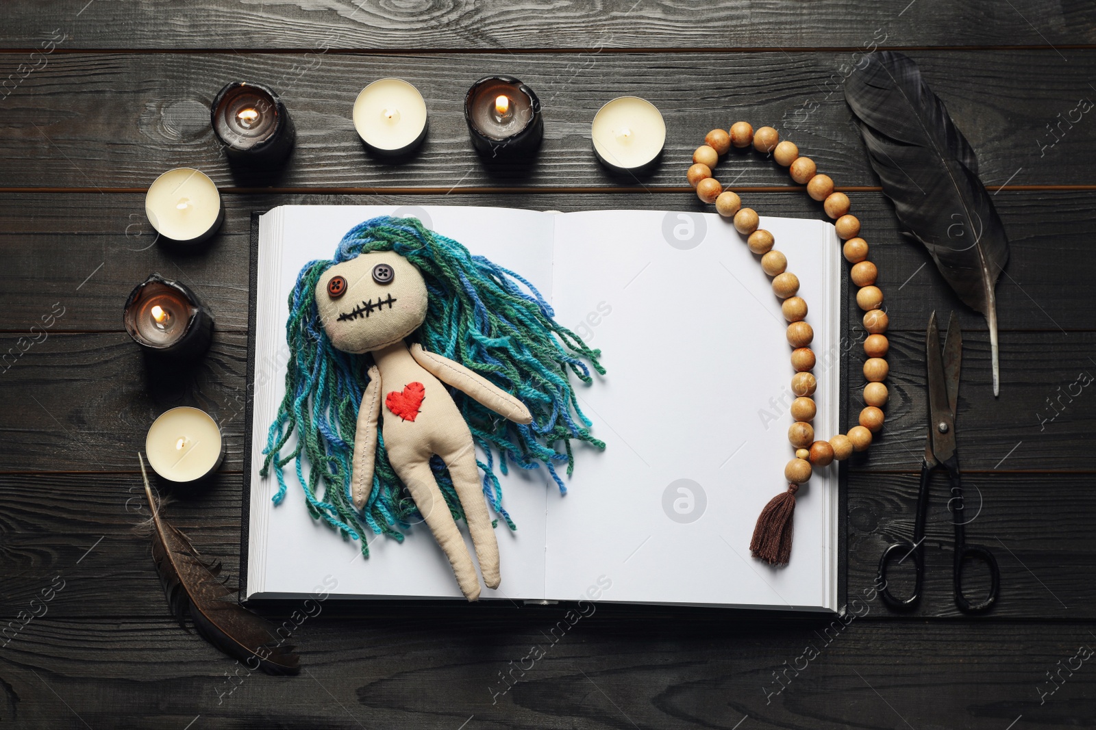 Photo of Flat lay composition with voodoo doll on dark wooden table