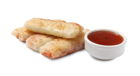 Delicious fried spring rolls and sauce isolated on white