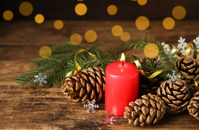 Photo of Burning candle and Christmas decor on wooden table, bokeh effect. Space for text