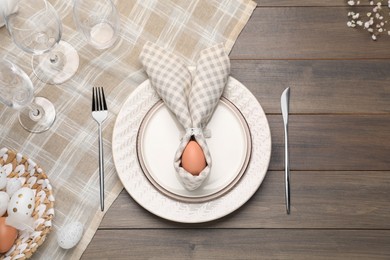 Photo of Festive table setting with bunny ears made of egg and napkin, flat lay. Easter celebration