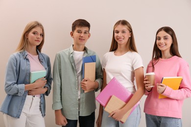 Group of teenage students with stationery on beige background