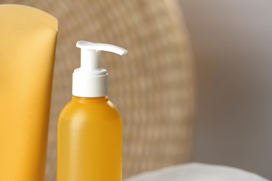 Photo of Bottle and tube of face cleansing products on blurred background, closeup. Space for text
