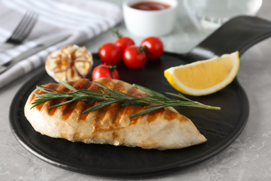 Photo of Delicious grilled chicken with vegetables on marble table