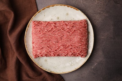 Fresh raw ground meat on brown textured table, top view