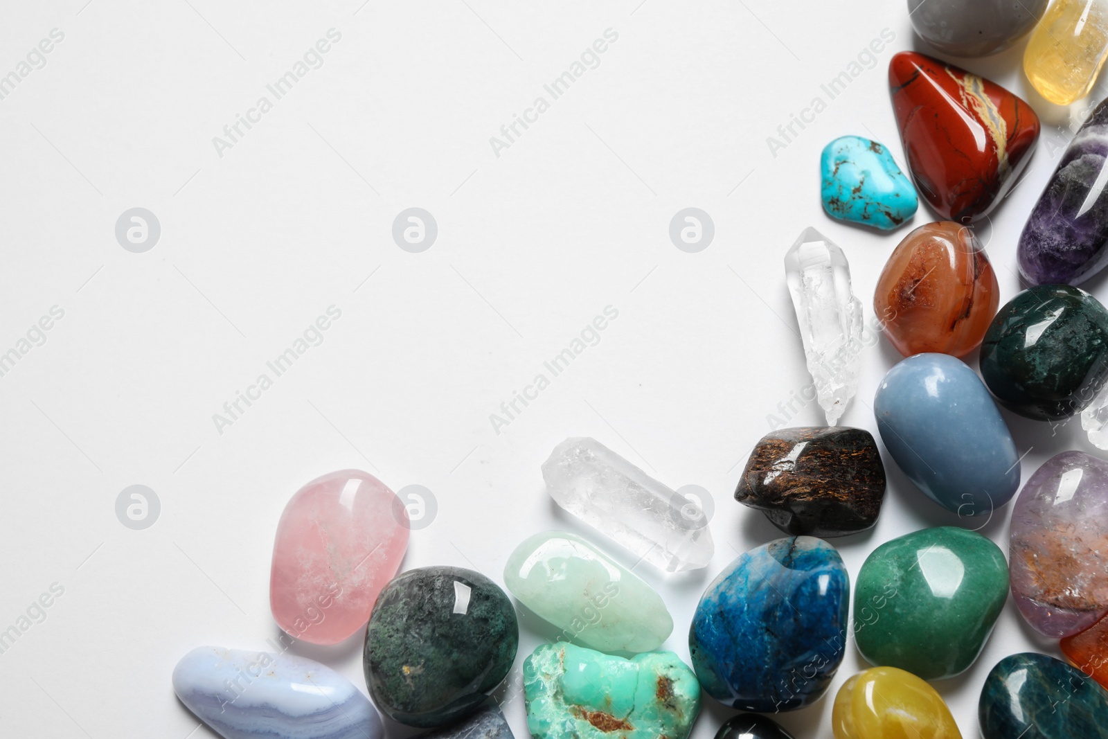 Photo of Different beautiful gemstones on white background, top view