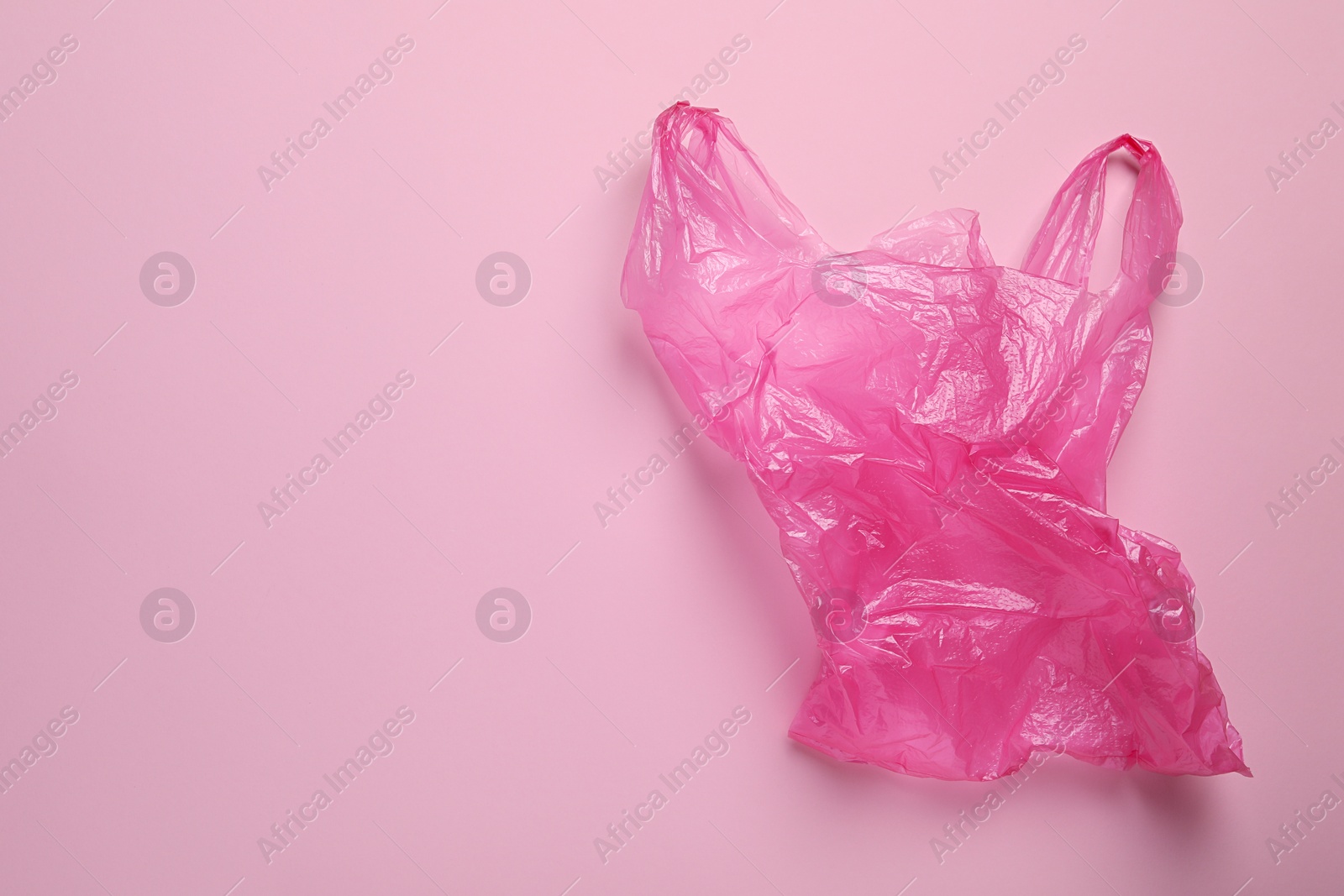 Photo of One plastic bag on pink background, top view. Space for text