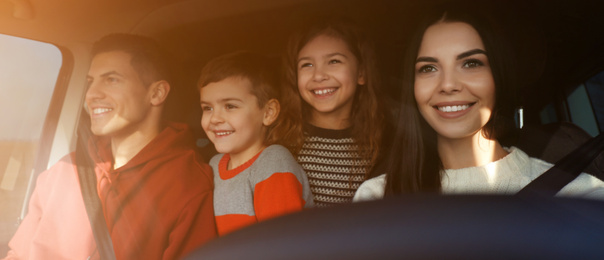 Image of Happy woman with her family inside modern car on sunny day. Banner design