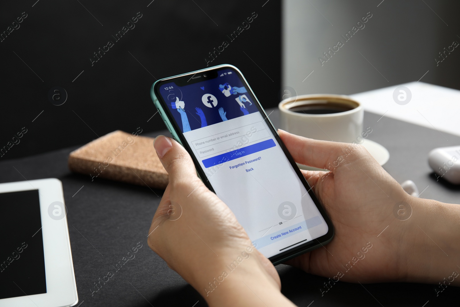 Photo of MYKOLAIV, UKRAINE - JULY 9, 2020: Woman holding Iphone 11 with Facebook app on screen at black table, closeup