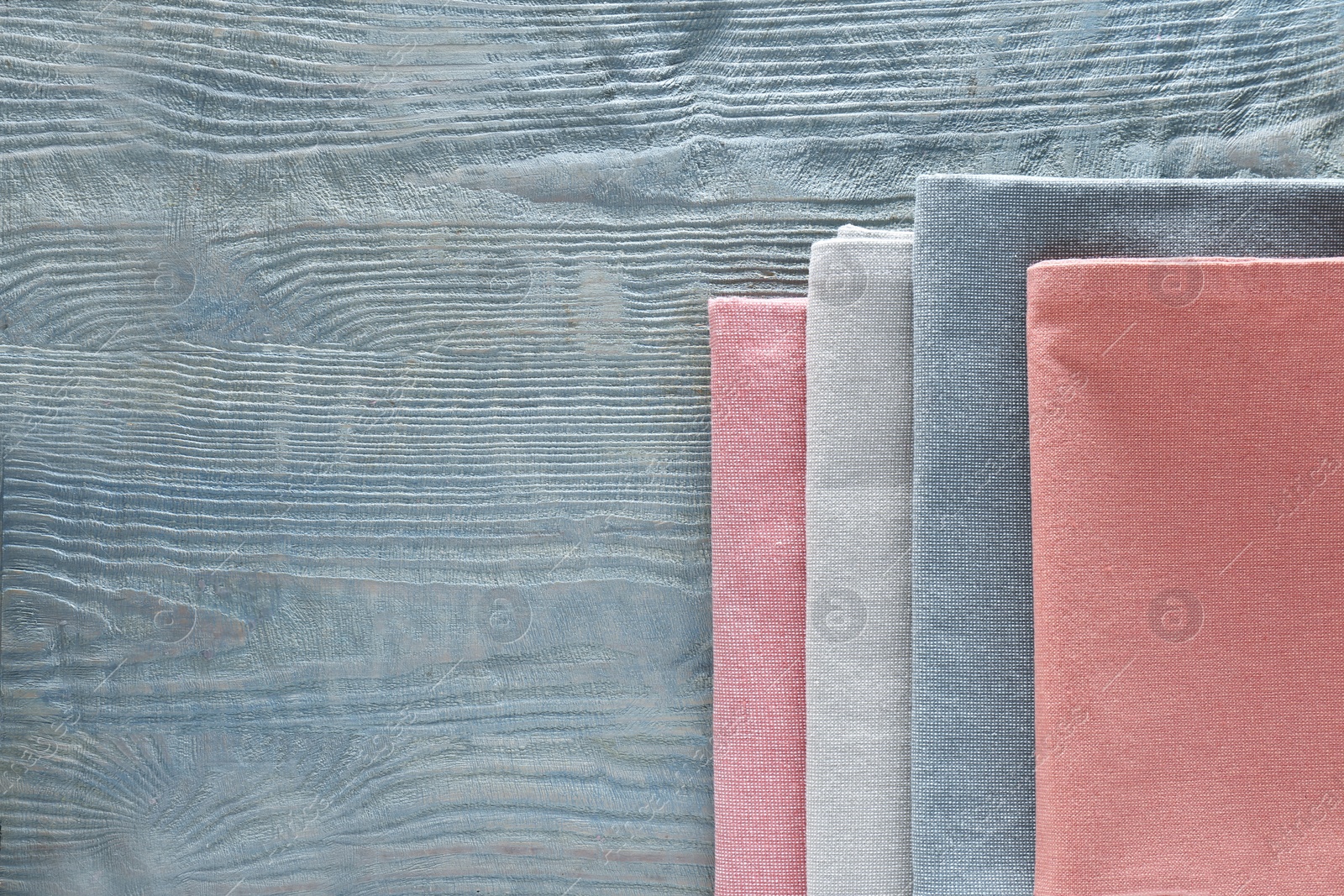 Photo of Different colorful napkins on wooden table, top view. Space for text